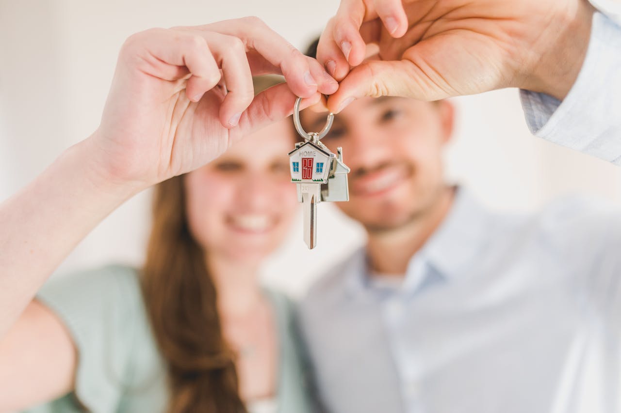 A smiling couple holding the keys to their new home together